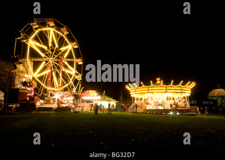 Riesenrad und Karussell beleuchtet in der Nacht auf einer Kirmes in Chesterfield Derbyshire East Midlands England Stockfoto