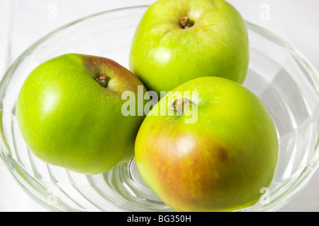 Drei Bramley Kochen Äpfel in eine Glasschüssel Stockfoto