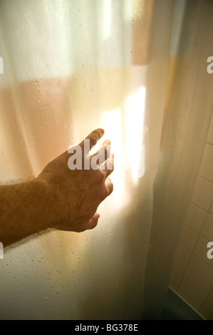 Mans Hand Eröffnung Duschvorhang im Bad Stockfoto