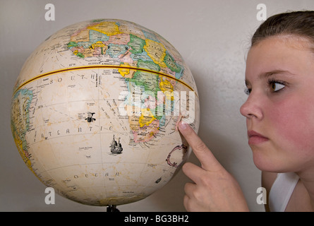 Ein Teenager-Studentin untersucht einen Globus Stockfoto