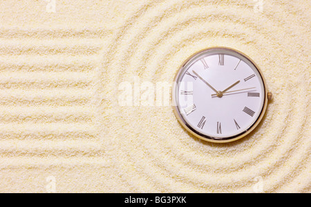 Alte Uhr auf Sand in eine Komposition aus den japanischen Steingarten Stockfoto