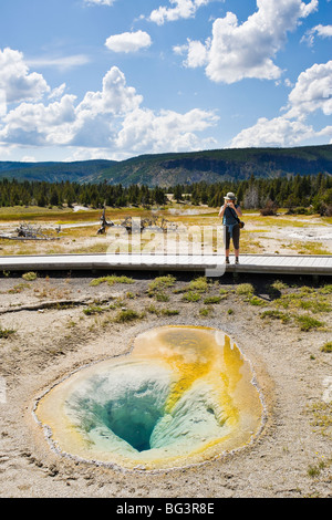 Ein Tourist nimmt ein Bild von einer kleinen heißen Quelle im oberen Geysir-Becken im Yellowstone-Nationalpark, Wyoming, USA. Stockfoto