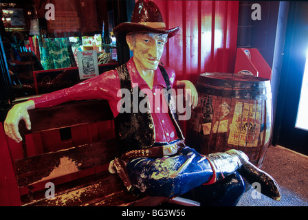 LifeSize Cowboy Figur sitzen auf einer Bank in Wand Drogerie, bekannte am Straßenrand Attraktion in Wand, South Dakota, USA. Stockfoto