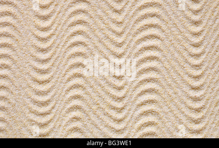 Textur aus gelbem Sand bedeckt mit Wellen Stockfoto