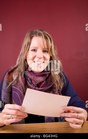 Hübsches Mädchen lächelnd mit Foto in der Hand. Stockfoto