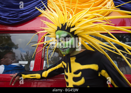 England, London, Notting Hill Carnival, kostümierten Teilnehmer und roten Bus Stockfoto