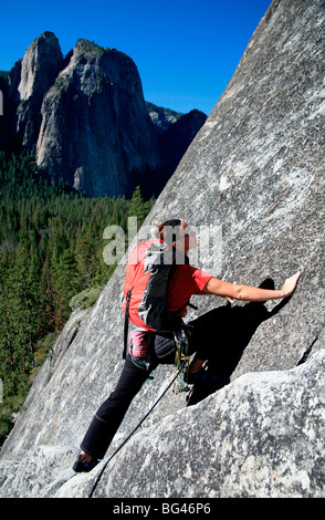 Eine Frau, Klettern auf Felsen gegenüber Cathedral Rock, in der Nähe von El Capitan, Yosemite Valley, California, Vereinigte Staaten von Amerika Stockfoto