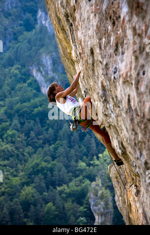 Kletterer greift überhängende Route auf Kalksteinfelsen der Gorge du Tarn, Massif Central, in der Nähe von Millau und Rodez, Frankreich Stockfoto