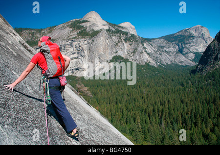 Bergsteiger besteigt Platten auf Basis der riesigen Felsen namens The Schürze, Washington Spalte und North Dome, Yosemite Valley, Kalifornien, USA Stockfoto