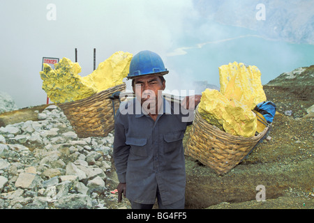 Mann engagiert in Schwefel Bergbau, eine Knochenarbeit und gefährliche Arbeit in der Kawah Ijen Krater, Vulkan Ijen, Ost-Java, Indonesien Stockfoto