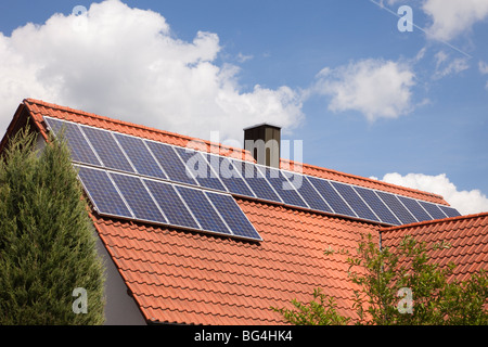 Photovoltaik-Solarzellen auf einem Hausdach an einem sonnigen Tag. Bayern, Deutschland, Europa. Stockfoto