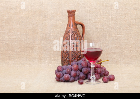 Kunst-Komposition aus eine große Flasche Ton, Trauben und einem Glas Stockfoto