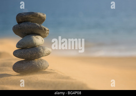 Stapel von vulkanischen Kieselsteine am Strand mit Sand weht Stockfoto