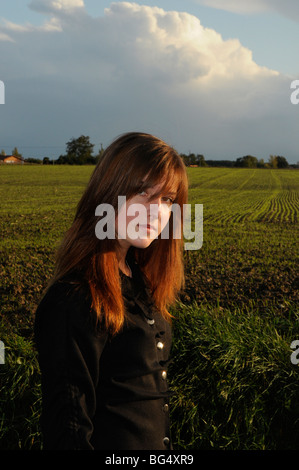 Teenager-Mädchen posiert im warmen Abendlicht in Landschaft. Stockfoto