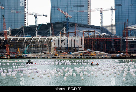 Arbeiter lag Dekorationen auf dem Wasser vor der Baustelle des Las Vegas Sands Corp. Marina Bay Sands in Singapur Stockfoto