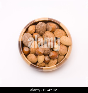 Holzschale mit gemischten Nüssen in ihren Schalen, Haselnüsse, Walnüsse und Mandeln gefüllt. Stockfoto