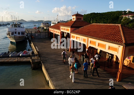 Cruz Bay Ferry Terminal St John US Virgin Islands | CRUZ BAY, U.S. Virgin Islands – Passagiere gehen in Richtung des Cruz Bay Fährterminals auf St. John, dem wichtigsten Tor der Insel für an- und Abreise. Das spanische Terminal mit Ziegeldach, das entlang des Loredon L. Boynes Sr. Dock gebaut wurde, bietet Fährverbindungen nach St. Thomas und zu den Britischen Jungferninseln und fungiert als Knotenpunkt des Verkehrsnetzes von St. John. Stockfoto