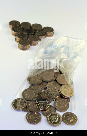 Stapel von 20p Münzen neben einem offenen Münze Tasche mit 20p Münzen aus Öffnung Stockfoto