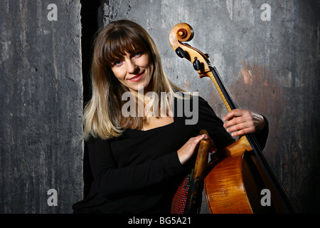 Schöne Violoncello Musiker auf graue Wand Hintergrund Stockfoto