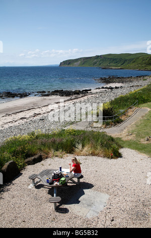 Frau mit einem Picknick am Strand von Kildonan, The Isle of Arran, Schottland, Juni 2009 Stockfoto