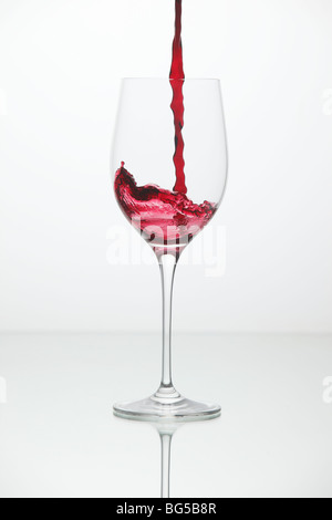 Rot Wein wird ein Glas gegossen Stockfoto