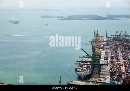 Ein erhöhter Blick zeigt ein Containerschiff im Hafen von Singapur angedockt. Stockfoto