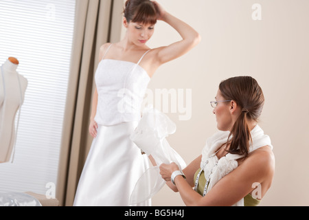 Art und Weisemodell passend weißes Brautkleid in erfolgreiche professionelle Frau Modedesigner Atelier Stockfoto