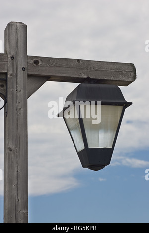 Eine verwitterte outdoor Leuchte vor blauem Himmel mit Wolken. Stockfoto