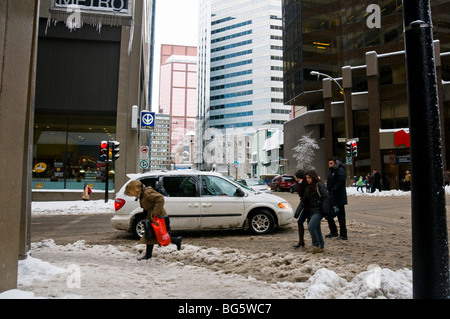 Menschen kämpfen mit der Mischung aus Matsch und Schnee in der Innenstadt von Montreal Stockfoto