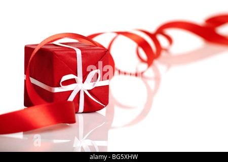 Rotes Geschenk mit einem roten Band über das Geschenk, isoliert auf weißem Hintergrund Stockfoto