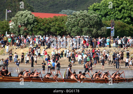 Ein Waka Taua (Krieg Kanu) übergibt Zuschauer auf Te Ti Bucht während Waitangi Day feiern, Neuseeland Stockfoto