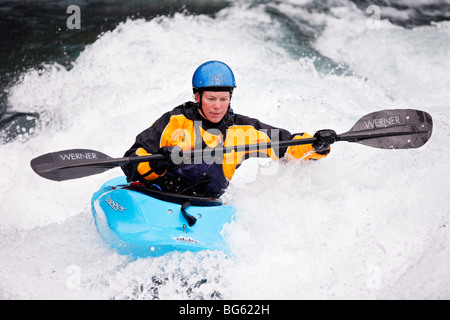 Heather Armitage Paddel durch ein Loch in einer Wildwasser-Kajak auf dem Kananaskis River, Kananaskis County, Alberta, Kanada Stockfoto