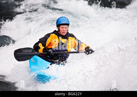 Heather Armitage Paddel durch ein Loch in einer Wildwasser-Kajak auf dem Kananaskis River, Kananaskis County, Alberta, Kanada Stockfoto