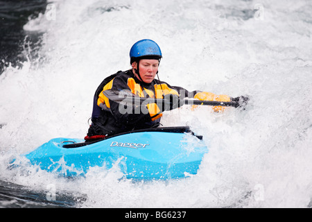 Heather Armitage Paddel durch ein Loch in einer Wildwasser-Kajak auf dem Kananaskis River, Kananaskis County, Alberta, Kanada Stockfoto