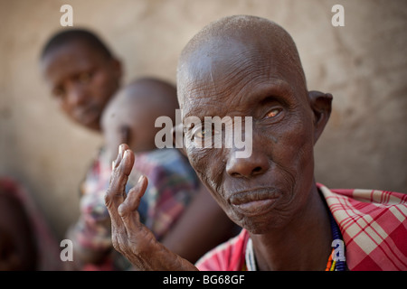 Eine ältere Frau Massai, auf einem Auge blind wartet darauf, von einem Arzt in einer Klinik in Kilombero, Manyara Region, Tansania gesehen werden. Stockfoto