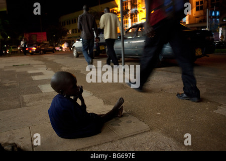 Ein junges Mädchen des Stammes Karamjong bittet auf den Straßen der Hauptstadt Kampala, Uganda. Stockfoto