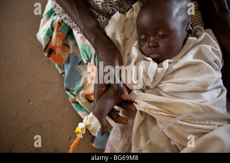 Eine Mutter hält ihr Kind, leidet unter Dehydratisierung in einem Krankenhaus in Amuria, Uganda. Stockfoto