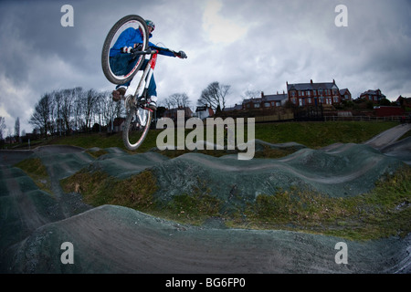 Mountainbike-Fahrer springt auf einem hügeligen Kurs Stockfoto