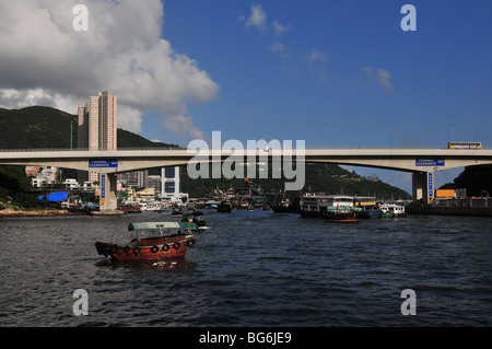 Die Nachmittagssonne scheint auf den Seiten von einem Sampan vor Anker vor der Ap Lei Chau Bridge, Aberdeen Harbour, Hong Kong, China Stockfoto