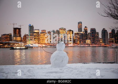 Unvollständige Schneemann im Stanley Park und die Skyline der Stadt in der Abenddämmerung, Vancouver, BC, Kanada Stockfoto