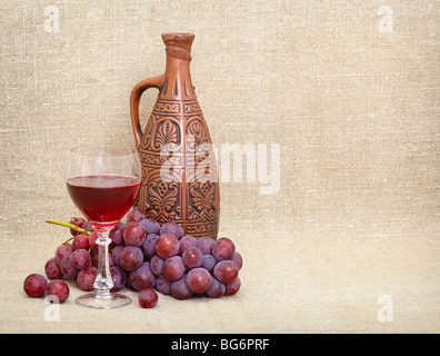 Tonkrug mit georgischen Wein, ein Glas und Trauben - ein Stillleben Stockfoto