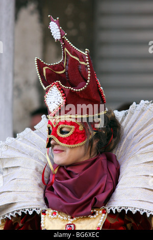 Frau trägt eine Maske und Kostüm vor der Basilika Markusplatz, Venedig, Italien Stockfoto