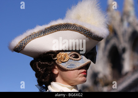 Frau trägt eine Maske und Kostüm vor der Basilika Markusplatz, Venedig, Italien Stockfoto