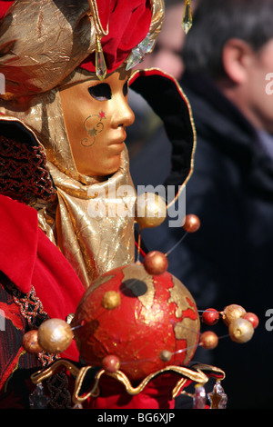 Nahaufnahme eines venezianischen Mann oder Frau trägt eine goldene Maske und Kostüm und hält einen Globus-förmigen kann in Venedig Karneval 2009 Stockfoto