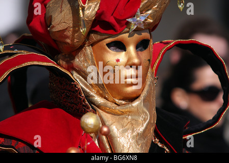 Nahaufnahme eines venezianischen Mann oder Frau trägt eine goldene Maske und Kostüm und hält einen Globus-förmigen kann in Venedig Karneval 2009 Stockfoto