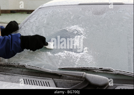 Eine frostige Auto Windschutzscheibe kratzen, an einem Wintermorgen Stockfoto