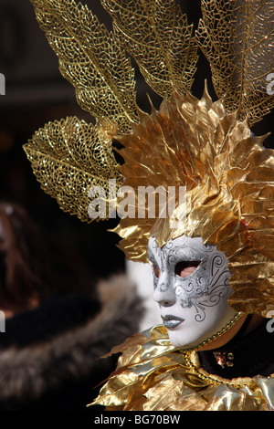 Nahaufnahme des Profils einer venezianischen Mann/Frau trug eine weiße Maske und Kostüm rot und gold in Venedig Karneval 2009 Stockfoto