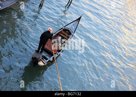 Venezianischen Gondoliere, die über einen Kanal in Venedig, ein paar genießt die Aussicht aus der Gondel Rudern Stockfoto