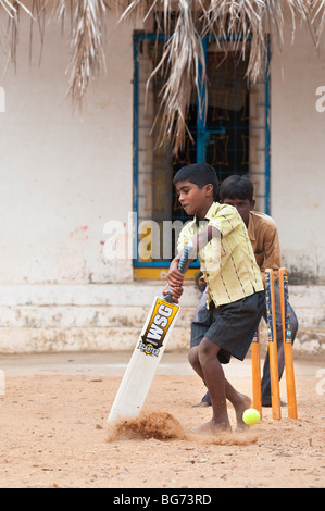 Ländlichen indischen Dorf jungen Kricket spielen in einem Dorf. Nallaguttapalli, Andhra Pradesh, Indien Stockfoto