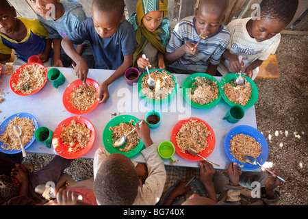 Kinder erhalten in Mererani, Tansania, die weltweit einzige Quelle der Tansanit Mahlzeiten in einer Küche. Stockfoto